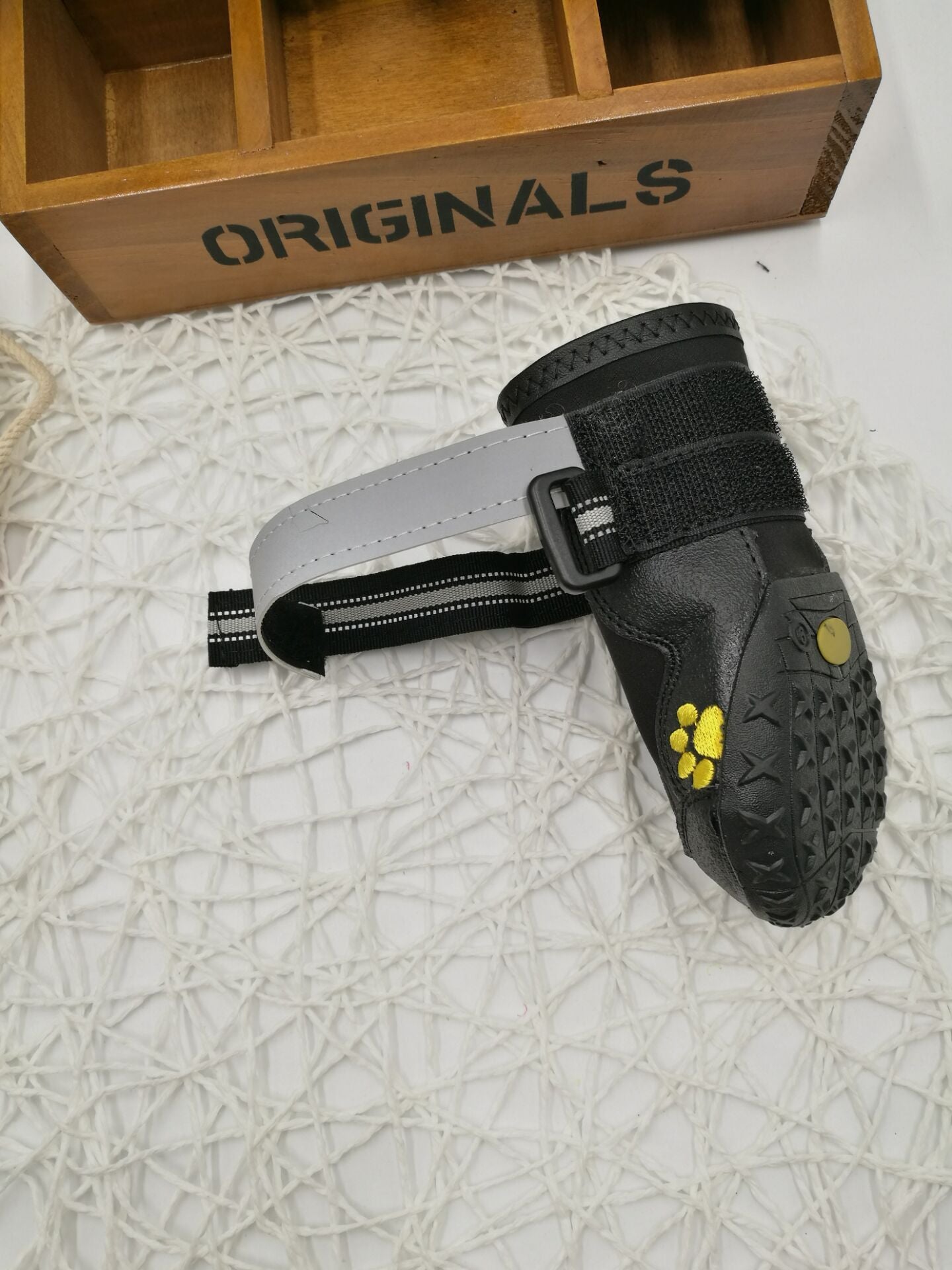 Underside view of dog boot showing non-slip rubber sole with paw print logo.