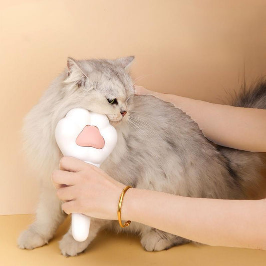 Paw-shaped pet brush removing loose fur and reducing hairballs in cats
